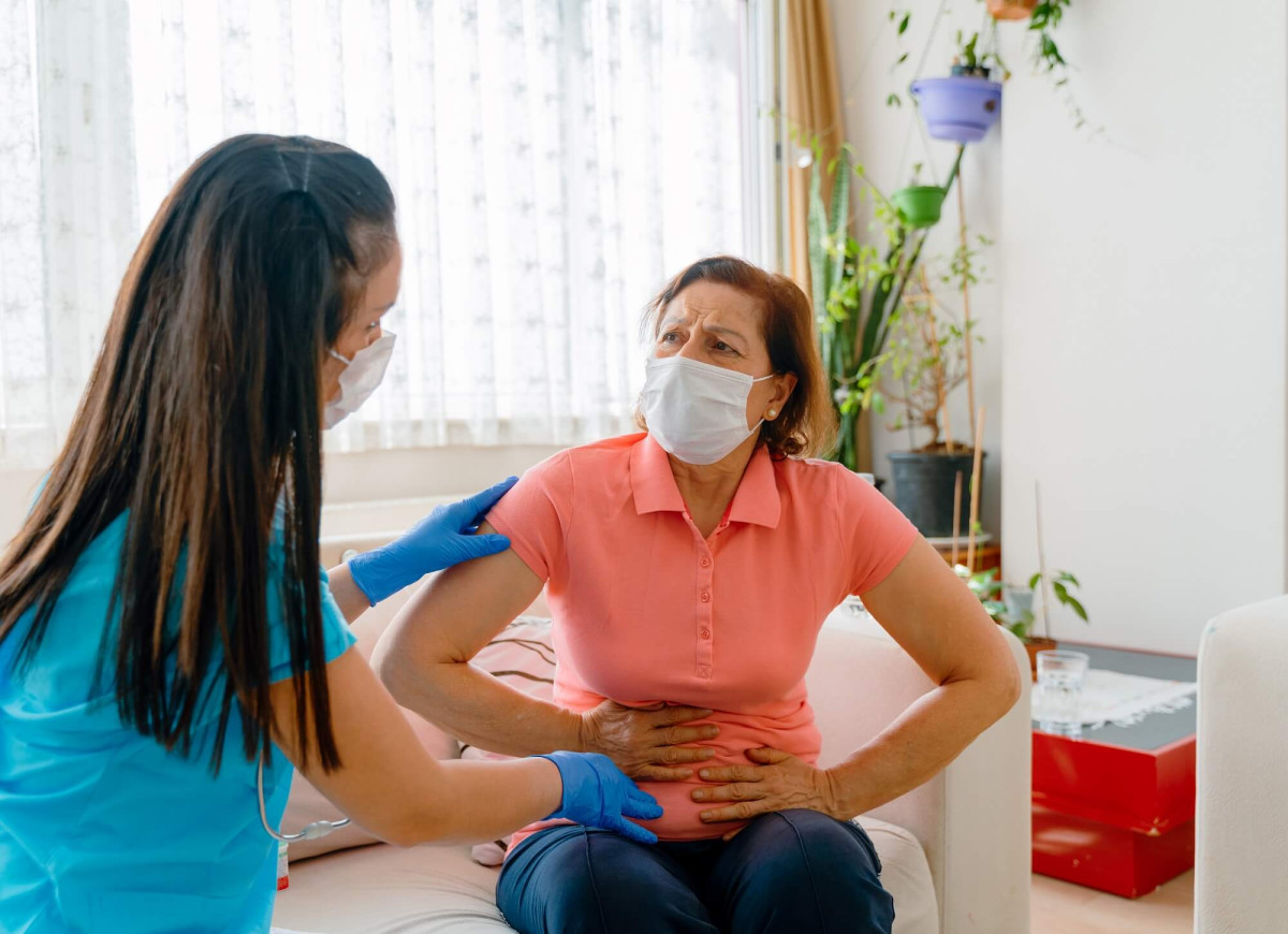 Woman with mask and stomach pain G 1248393962